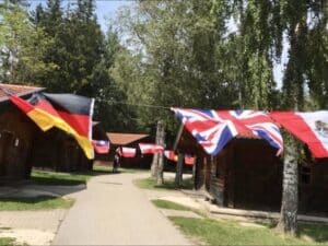 Campanlage mit mehreren Blockhütten und aufgespannten internationalen Flaggen