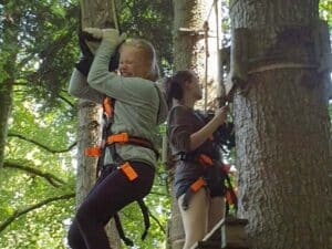 Mädchen an Seilbahn im Hochseilgarten