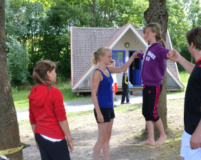 Trainer helfen Teilnehmerin beim Slacklining