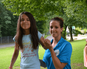 Trainerin hilft Teilnehmer auf Slackline